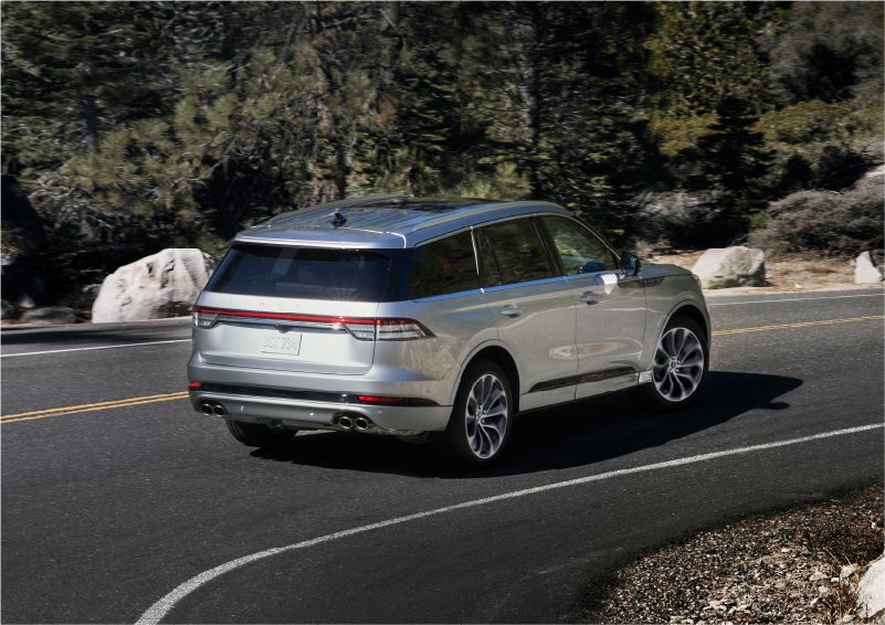 A 2023 Lincoln Aviator® Grand Touring model is shown being driven on a tight turn of a mountain road | Hooks Lincoln in Fort Worth TX