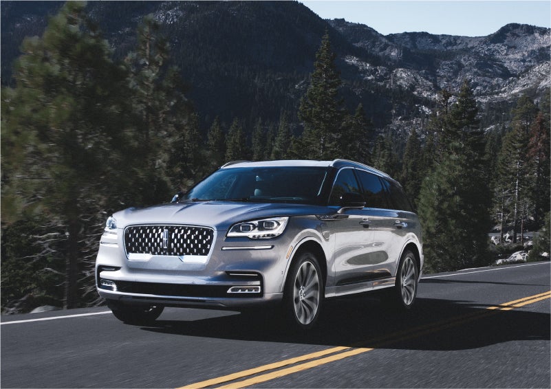 A 2023 Lincoln Aviator® Grand Touring SUV being driven on a winding road to demonstrate the capabilities of all-wheel drive | Hooks Lincoln in Fort Worth TX