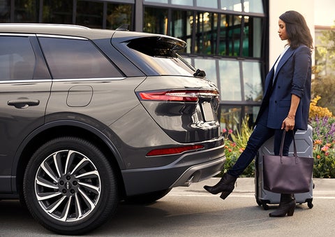 A woman with her hands full uses her foot to activate the available hands-free liftgate. | Hooks Lincoln in Fort Worth TX