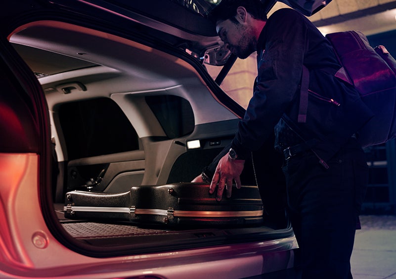 A man is shown loading cargo into the rear of a 2024 Lincoln Corsair® SUV with the second-row seats folded flat. | Hooks Lincoln in Fort Worth TX