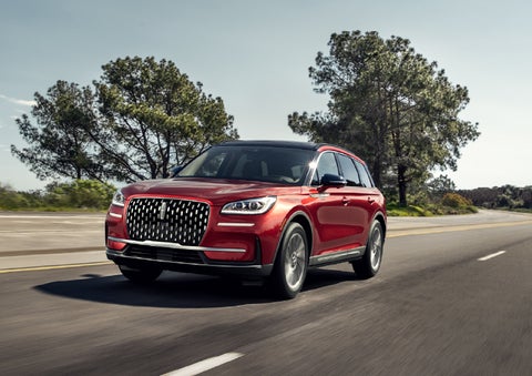 A 2026 Lincoln Corsair® SUV is shown being driven on a country road. | Hooks Lincoln in Fort Worth TX