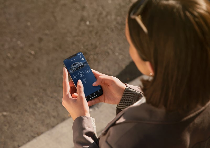 A person is shown interacting with a smartphone to connect to a Lincoln vehicle via the Lincoln Way® app. | Hooks Lincoln in Fort Worth TX