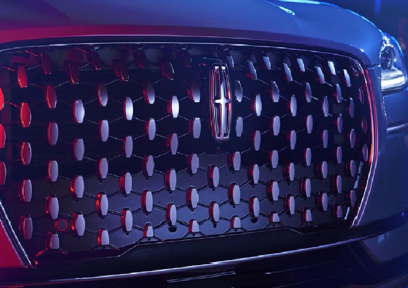 The grille of a 2025 Lincoln Corsair&reg; SUV reflects neon light at night. | Hooks Lincoln in Fort Worth TX