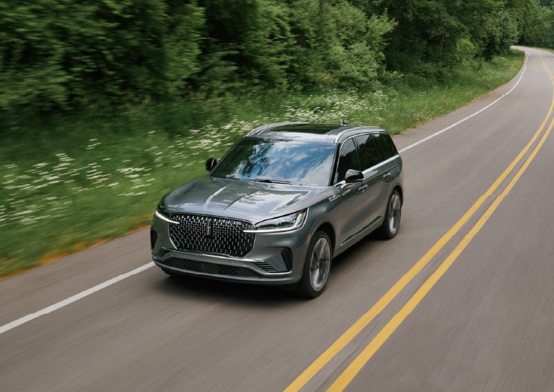 A 2027 Lincoln Aviator® SUV is being driven down a road. | Hooks Lincoln in Fort Worth TX