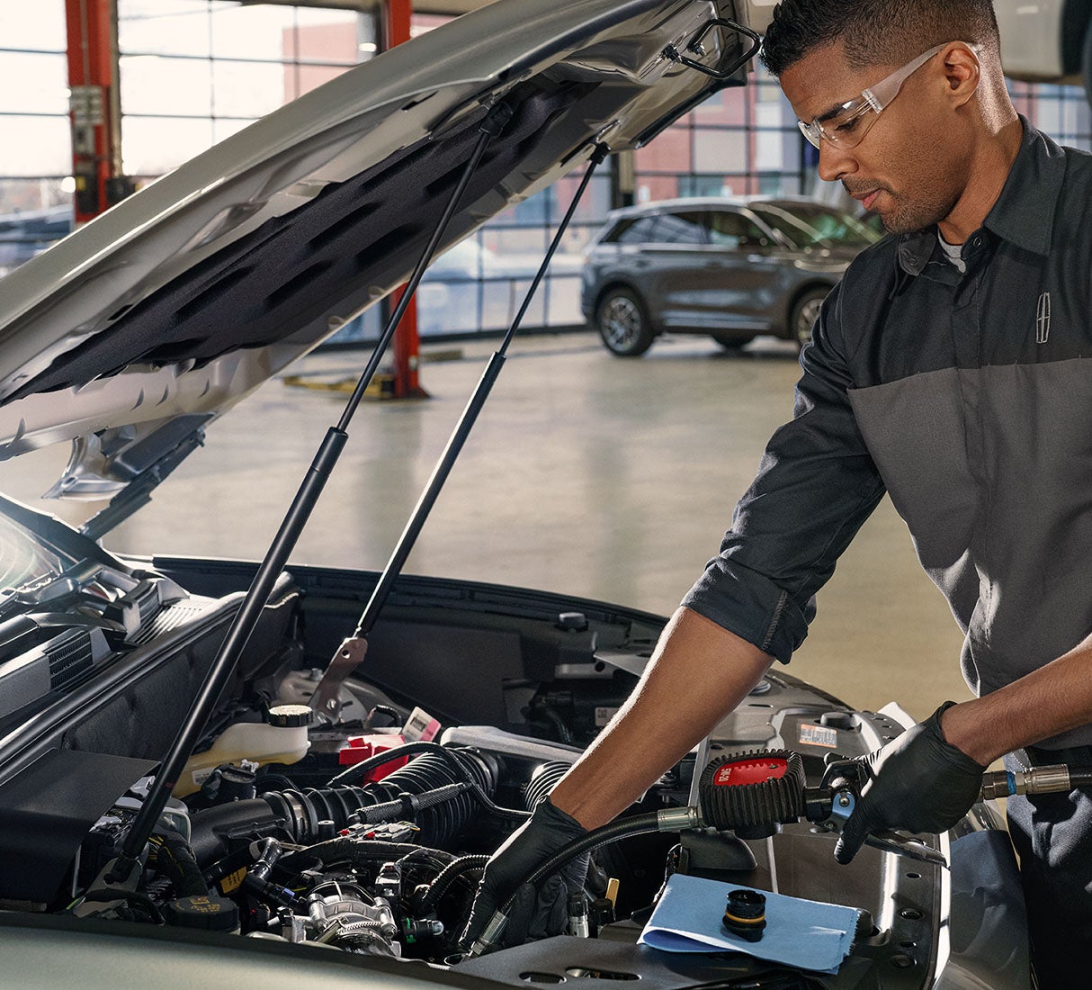 car technician check engine under the car hood - Hooks Lincoln in Fort Worth TX