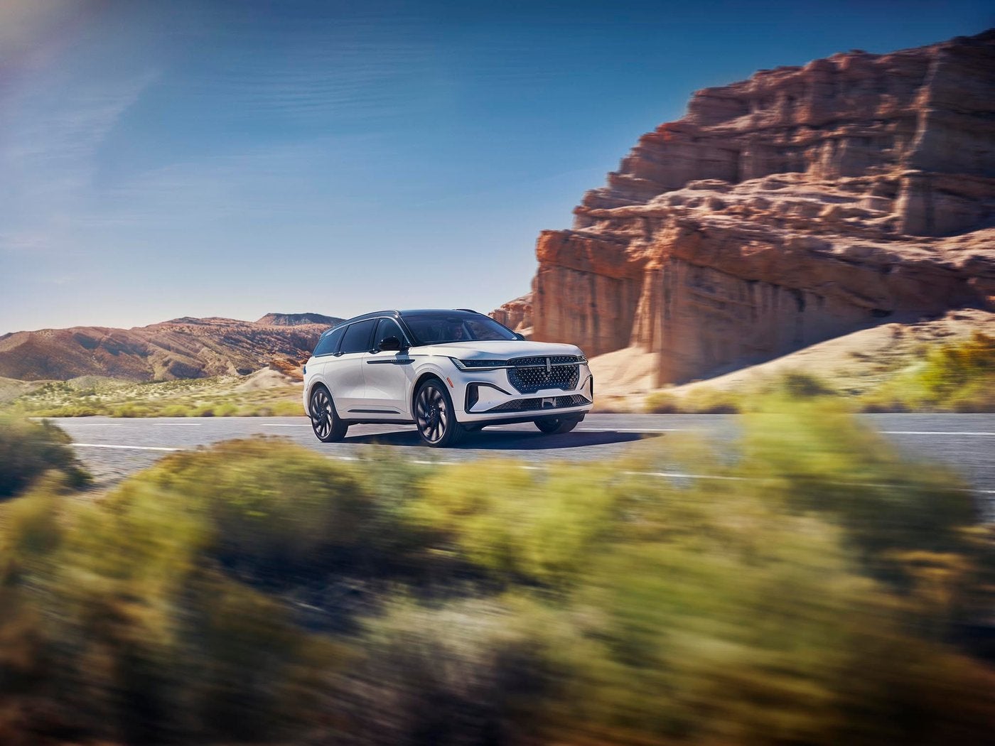 White Lincoln SUV driving a sunny desert highway, the kind of heat Fort Worth TX AC systems face