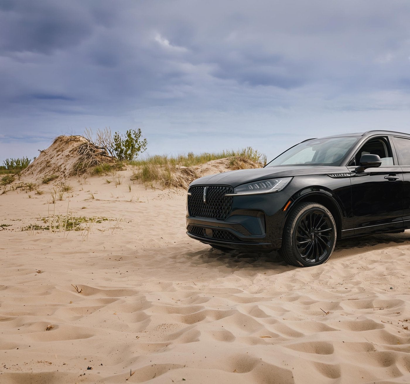 Black Lincoln Aviator parked on sand near a lakeshore, ready for a road trip from Fort Worth TX